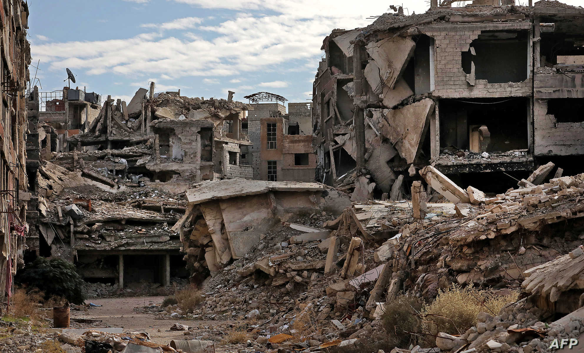 Destroyed buildings are pictured at the Palestinian Yarmuk camp, on the southern outskirts of the Syrian capital Damascus, on November 25, 2020 as families visit the destroyed residential district to inspect their abandoned apartments and register with the authorities with the hope of eventually returning to their homes. - In May 2018, the Syrian government retook the Palestinian camp of Yarmuk and adjacent suburbs after a pulverising assault that lasted nearly a month to expel jihadists who controlled the area for years. That placed the regime in full control of the entire capital for the first time since 2012. Yarmuk is a camp turned into a bustling neighbourhood before the seven-year civil war in Syria, with most of its residents of Palestinian origin. (Photo by LOUAI BESHARA / AFP)