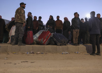 Syrian refugees living in Turkey wait by their belongings for transportation at the northern Bab al-Hawa border crossing, on February 17, 2023, as they return to Syria in the aftermath of a deadly earthquake. - Turkey this week allowed Syrians under its protection who hold ID cards from one of the quake-hit provinces to leave for between three and six months, a rule change designed to reunite families on both sides of the border hit by the February 6 disaster, which has killed more than 41,000 people and displaced millions across both countries. (Photo by Omar HAJ KADOUR / AFP)