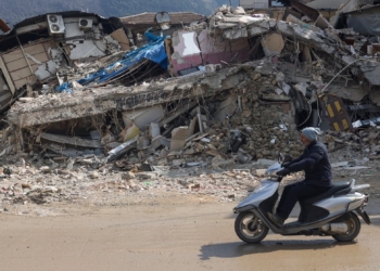 A man rides a motorbike past destroyed buildings in Antakya, southeastern Turkey, Tuesday, Feb. 21, 2023. The death toll in Turkey and Syria rose to eight in a new and powerful earthquake that struck two weeks after a devastating temblor killed nearly 45,000 people, authorities and media said Tuesday. (AP Photo/Unal Cam)