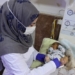 A nurse takes care of a newborn at the al-Rahma Hospital in the Syrian town of Darkush, in the Idlib province, on January 16, 2022. - In a northwest Syria hospital that provides free healthcare to around 30,000 people a month, the flow of patients rarely stops and yet the facility is slated to stop services. The Darkush hospital located in Idlib province is one of many hospitals in the region that risks closing down because of dwindling foreign aid that is causing shortages in medicine and equipment. (Photo by OMAR HAJ KADOUR / AFP)